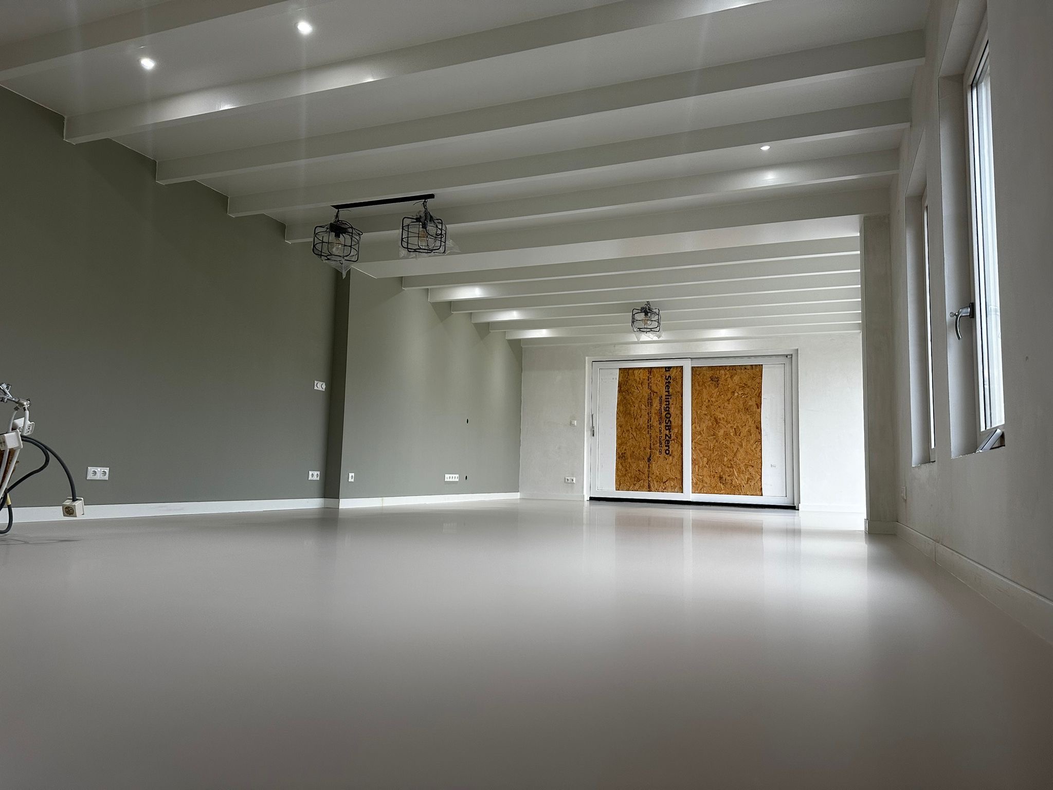 Ruime zolderverdieping met witte balken tijdens renovatie