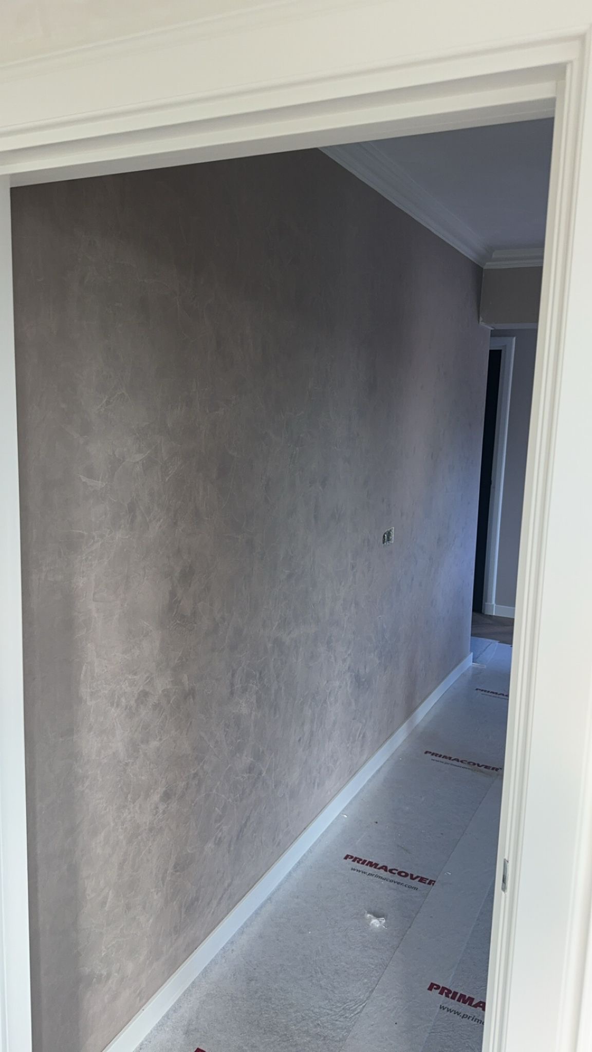 Decoratieve betonlook wandafwerking met spuitwerk